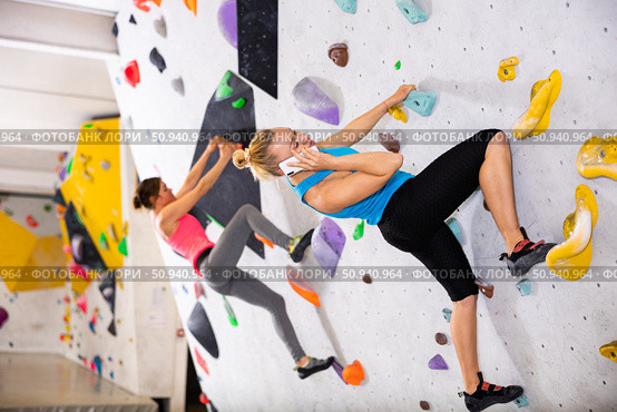 Woman having phone call during training in bouldering gym. Стоковое фото, фотограф Яков Филимонов / Фотобанк Лори