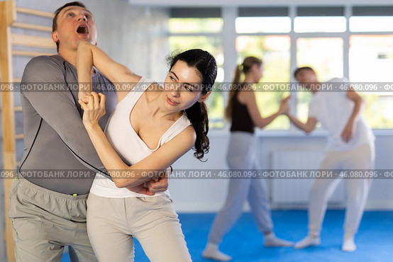 Woman hits man attacker on head during self-defense training session led by trainer. Стоковое фото, фотограф Яков Филимонов / Фотобанк Лори