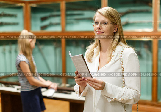 Woman holding guidebook in museum of art, girl on background. Стоковое фото, фотограф Яков Филимонов / Фотобанк Лори