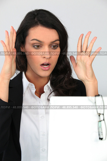 Woman holding her hands up in shock at a board left blank for your message. Стоковое фото, агентство Ingram Publishing / Фотобанк Лори