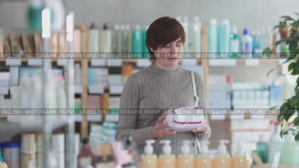 Woman in autumn clothes chooses feminine pads in a supermarket. Стоковое видео, видеограф Яков Филимонов / Фотобанк Лори