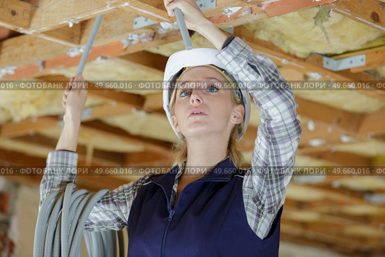 woman in builder hardhat working in ceiling. Стоковое фото, агентство Ingram Publishing / Фотобанк Лори