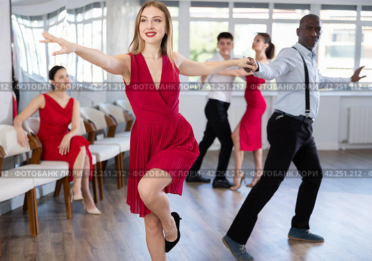 Woman in red dress practicing playful jitterbug in dance studio. Стоковое фото, фотограф Яков Филимонов / Фотобанк Лори