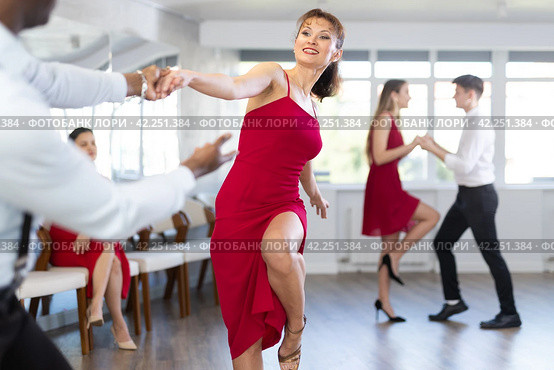 Woman in red dress practicing playful jitterbug in dance studio. Стоковое фото, фотограф Яков Филимонов / Фотобанк Лори