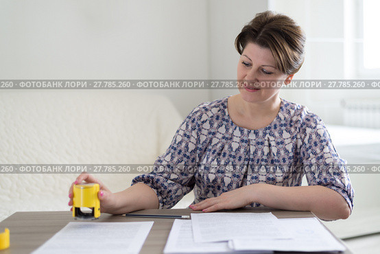 Woman individual entrepreneur puts a seal on documents. Стоковое фото, фотограф Володина Ольга / Фотобанк Лори