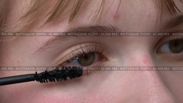 Woman is shown in an extreme close-up applying mascara to her brown eyes with the tip of brush to prevent clumping. Mascara may enhance and define appearance of eyes. Extreme close-up view process. Стоковое видео, видеограф А. А. Пирагис / Фотобанк Лори