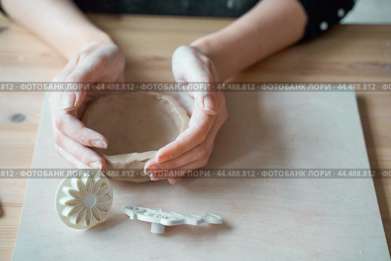 Woman making pottery, hands closeup, blurred background, focus on potters, palms with pottery. Turning passion into a job. Стоковое фото, фотограф Natalia Gdovskaia / Фотобанк Лори
