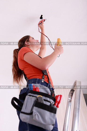 Woman measuring a wire’s electrical current. Стоковое фото, агентство Ingram Publishing / Фотобанк Лори