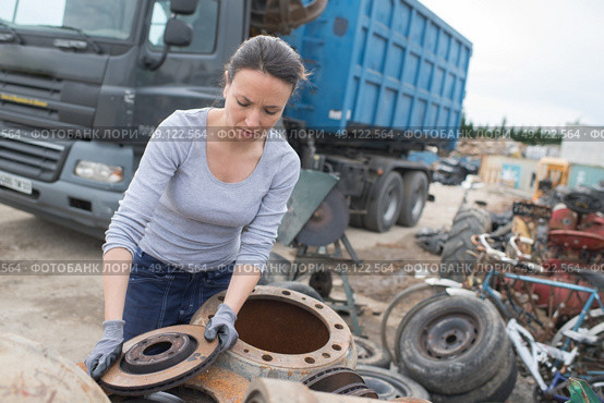 woman mechanic picking axle in car scrap yard. Стоковое фото, агентство Ingram Publishing / Фотобанк Лори