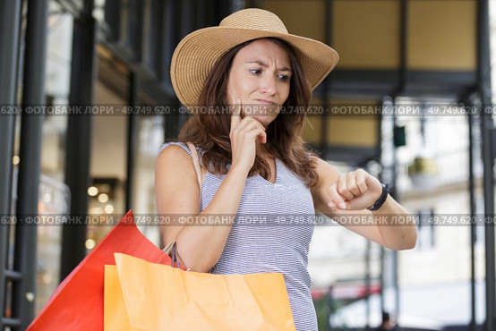 woman out shopping ruefully looking at her wristwatch. Стоковое фото, агентство Ingram Publishing / Фотобанк Лори