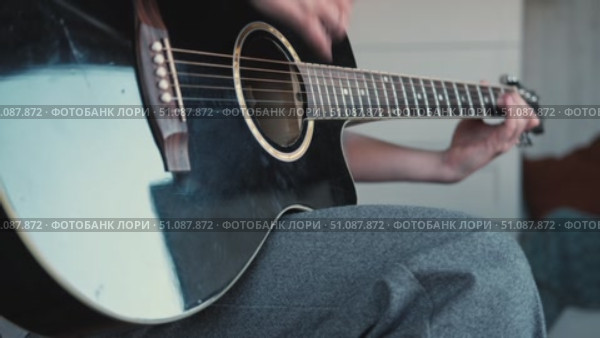 Woman Practicing Guitar in Cozy Room at Home. Strumming black acoustic guitar. Female learning to play music. Person hand on a guitar neck. Guitarist working on melody, performance, practice indoors. Стоковое видео, видеограф Марина Демидюк / Фотобанк Лори