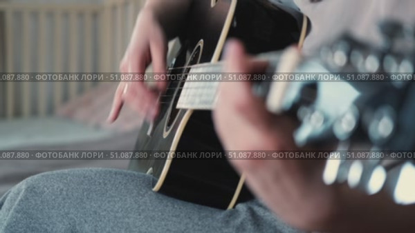 Woman Practicing Guitar in Cozy Room at Home. Strumming black acoustic guitar. Female learning to play music. Person hand on a guitar neck. Guitarist working on melody, performance, practice indoors. Стоковое видео, видеограф Марина Демидюк / Фотобанк Лори