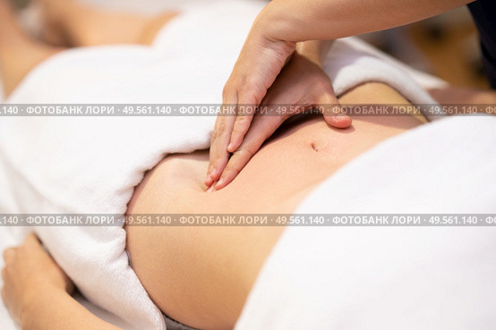 Woman receiving a belly massage in a physiotherapy center. Female patient is receiving treatment by professional osteopathy therapist.. Woman receiving a belly massage in a physiotherapy center. Стоковое фото, агентство Ingram Publishing / Фотобанк Лори