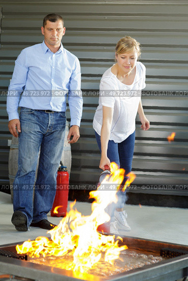 woman showing how to operate fire extinguisher. Стоковое фото, агентство Ingram Publishing / Фотобанк Лори