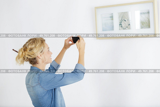 woman takes picture of paintings. Редакционное фото, агентство Ingram Publishing / Фотобанк Лори