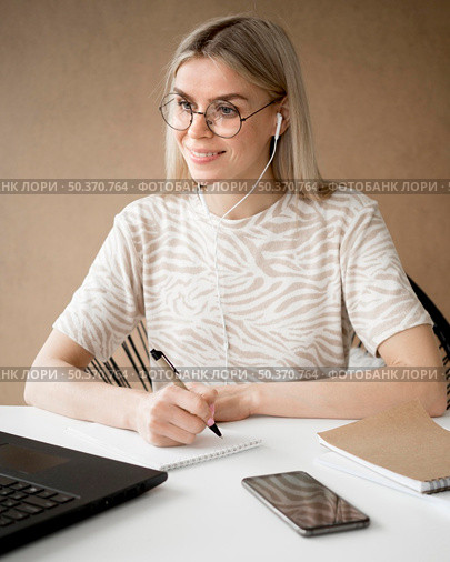 woman taking notes smiles. Стоковое фото, агентство Ingram Publishing / Фотобанк Лори