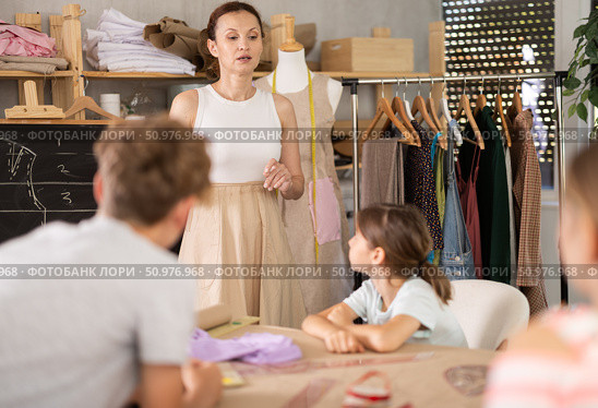 Woman teacher at blackboard conducts theoretical lesson for sewing school children students. Стоковое фото, фотограф Яков Филимонов / Фотобанк Лори