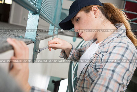 woman tightens screw brackets vertical blind headrails. Стоковое фото, агентство Ingram Publishing / Фотобанк Лори
