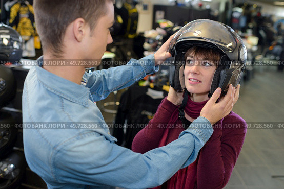 woman trying on a motorcycle helmet. Стоковое фото, агентство Ingram Publishing / Фотобанк Лори