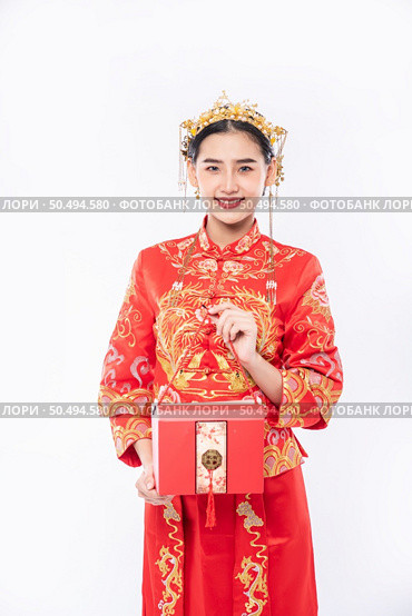 Woman wear Cheongsam suit ready to give red bag to sister for surprising in traditional day. Стоковое фото, агентство Ingram Publishing / Фотобанк Лори