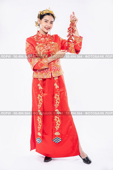 Woman wear Cheongsam suit smile to get Firecrackers from relative in chinese new year. Стоковое фото, агентство Ingram Publishing / Фотобанк Лори