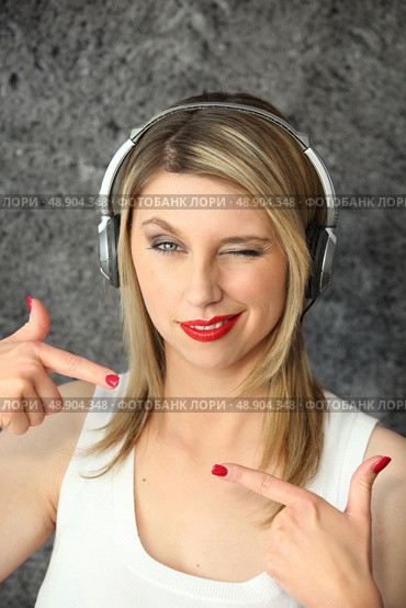 Woman winking with audio headphones. Стоковое фото, агентство Ingram Publishing / Фотобанк Лори