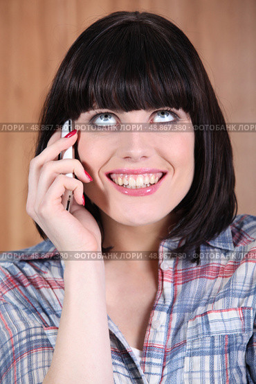 Woman with a broad grin talking on the phone. Стоковое фото, агентство Ingram Publishing / Фотобанк Лори
