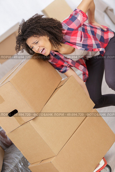 woman with backache while lifting box. Стоковое фото, агентство Ingram Publishing / Фотобанк Лори