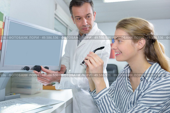 Woman with optician holding glasses. Стоковое фото, агентство Ingram Publishing / Фотобанк Лори