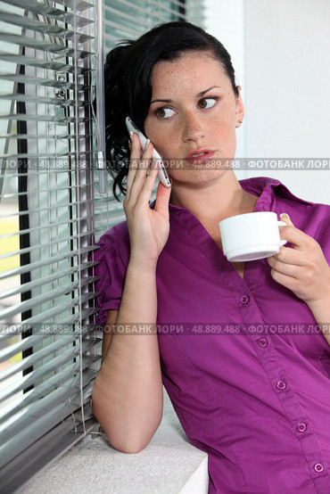 Woman with telephone and coffee cup. Стоковое фото, агентство Ingram Publishing / Фотобанк Лори