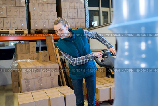 woman working in a warehouse using pallet truck. Стоковое фото, агентство Ingram Publishing / Фотобанк Лори