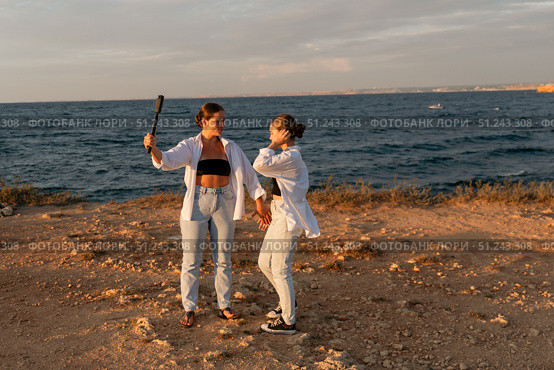 Women Selfie Beach Sunset - Two women take a selfie on a beach at sunset. Стоковое фото, фотограф svetograph / Фотобанк Лори