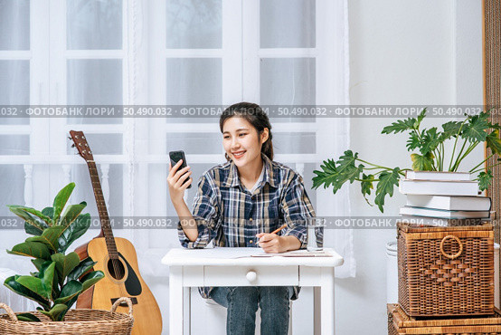Women sit at the desk and use the phone to coordinate. Стоковое фото, агентство Ingram Publishing / Фотобанк Лори