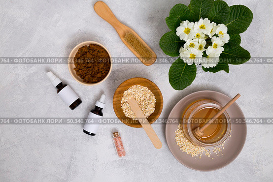wooden brush honey oats himalayan rock salt essential oil bottle with primula flowers vase concrete background. Стоковое фото, агентство Ingram Publishing / Фотобанк Лори