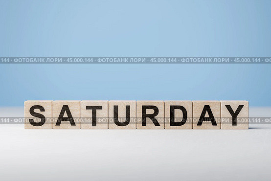 Word Saturday on wooden cubes. Weekday concept. Saturday inscription on wooden cubes on blue background. copy space. Стоковое фото, фотограф Павел Муравьев / Фотобанк Лори