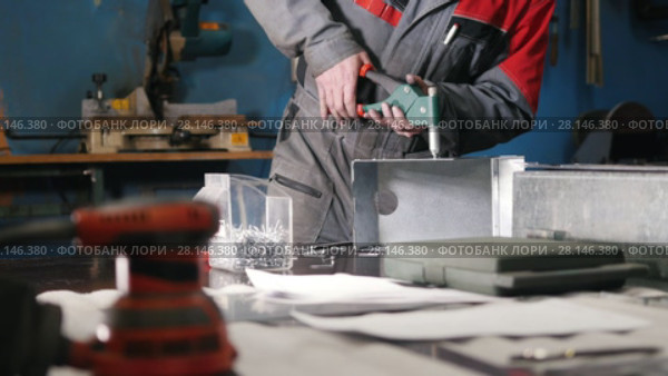 Worker assembling the metal part by hand with pliers, tools for grinding metal and metal details in the foreground. Стоковое видео, видеограф Константин Шишкин / Фотобанк Лори