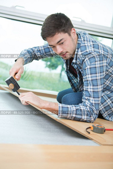 worker fixing parquet in a house. Стоковое фото, агентство Ingram Publishing / Фотобанк Лори