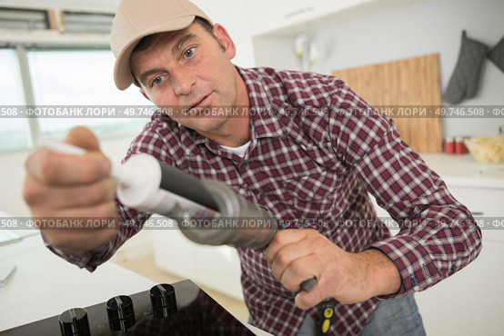 worker holding silicone sealant. Стоковое фото, агентство Ingram Publishing / Фотобанк Лори