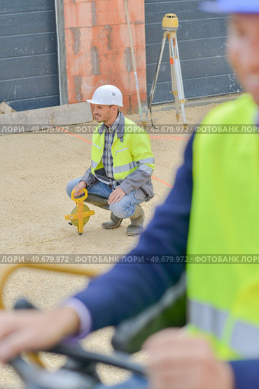 workers examining digger at construction site. Стоковое фото, агентство Ingram Publishing / Фотобанк Лори