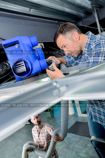 workers fixes that ventilation box. Стоковое фото, агентство Ingram Publishing / Фотобанк Лори