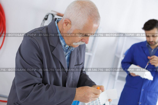 Workers screwing up electrical units. Стоковое фото, агентство Ingram Publishing / Фотобанк Лори