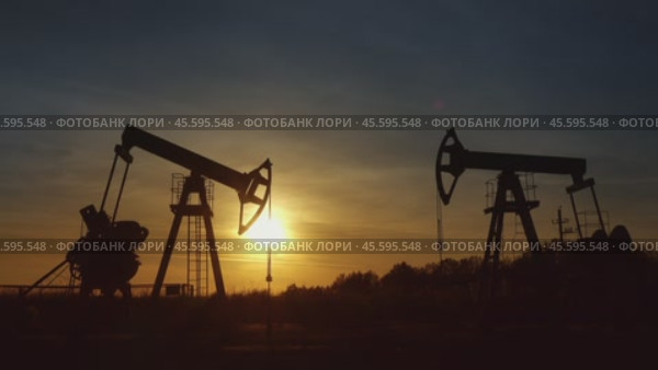 Working oil pumps silhouette against sunset. Стоковое видео, видеограф Михаил Коханчиков / Фотобанк Лори