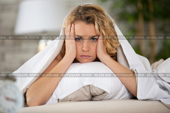 worried young woman laying in bed sleepless at night. Стоковое фото, агентство Ingram Publishing / Фотобанк Лори