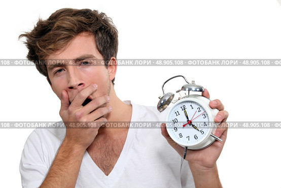 Yawning man holding alarm clock. Стоковое фото, агентство Ingram Publishing / Фотобанк Лори