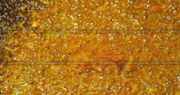 Yellow natural moving background. The process of overcooking carrots in vegetable oil. Bubbles of boiling oil swell and collapse. Стоковое видео, видеограф Константин Мерцалов / Фотобанк Лори