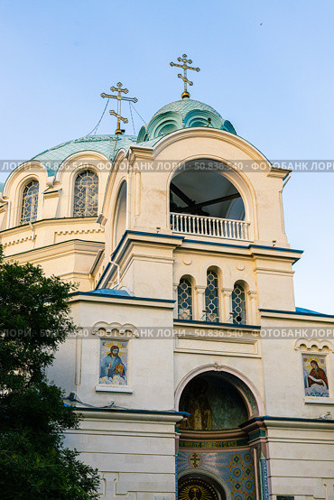 Yevpatoria, Russian Federation - July 05, 2025: Beautiful architectural details of a church with blue domes and crosses, showcasing intricate design and religious significance in a serene setting. Редакционное фото, фотограф Ирина Ручушкина / Фотобанк Лори