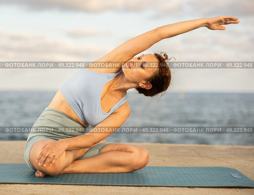 Yoga practice on embankment, female athlete fulfil carry out padmasana svastikasana, Siddhasana. Стоковое фото, фотограф Яков Филимонов / Фотобанк Лори