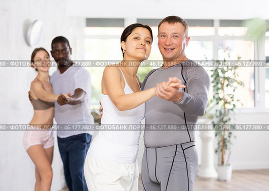Young Asian woman and European man dancing as couple in dance studio. Стоковое фото, фотограф Яков Филимонов / Фотобанк Лори