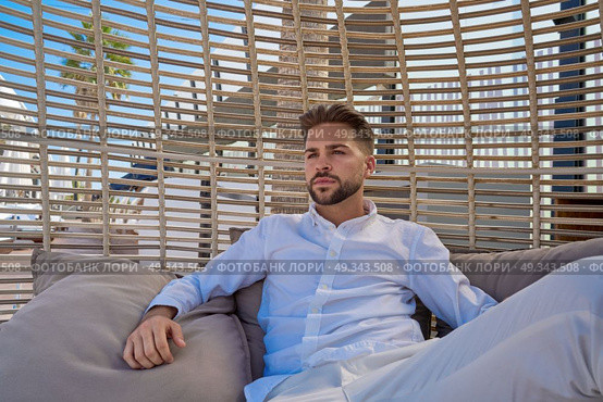 young beard man relaxed in a beach parasol hammock at summer. Стоковое фото, агентство Ingram Publishing / Фотобанк Лори