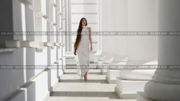 Young beautiful girl in a long white dress walks in the columned hall. Стоковое видео, видеограф Андрей Аркуша / Фотобанк Лори